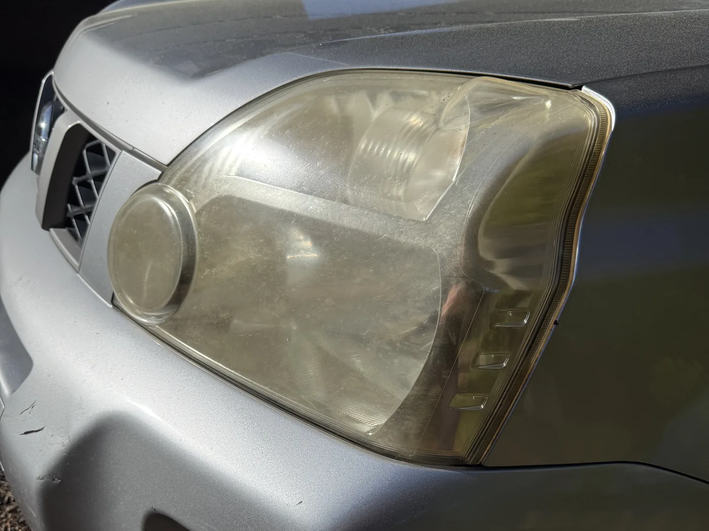 Before: yellowed, hazy headlight lens with the clear coat broken down